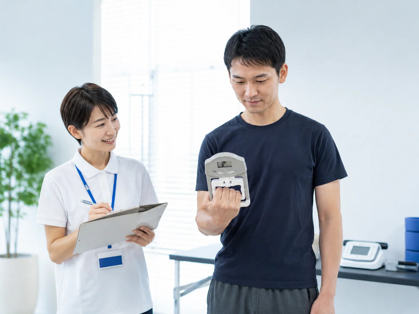 スタッフの案内を受けながら握力を測定する様子